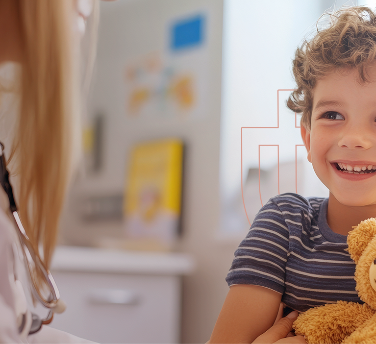 Médica pediatra com criança feliz segurando ursinho